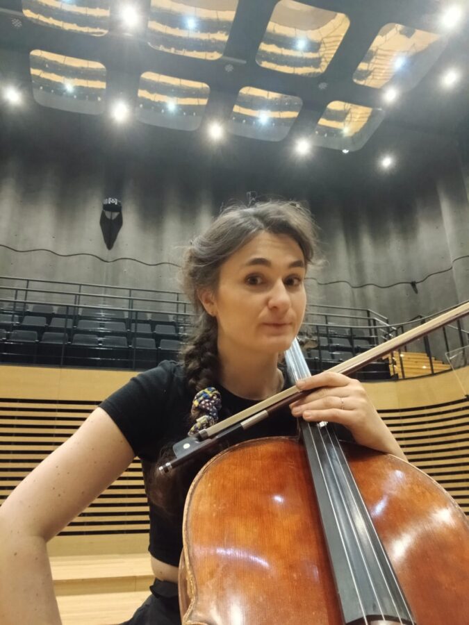 Zuzanna Sosnowska z wiolonczelą na scenie sali koncertowej